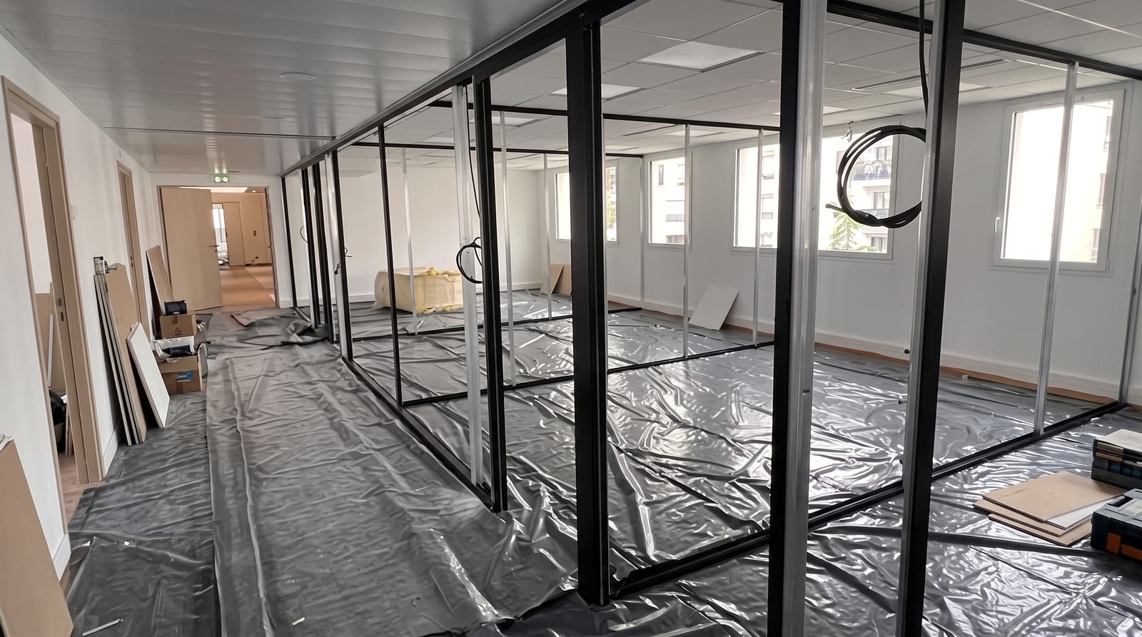 Chantier d'aménagement de bureaux avec cloisons vitrées et sol protégé — CAP OFFICE